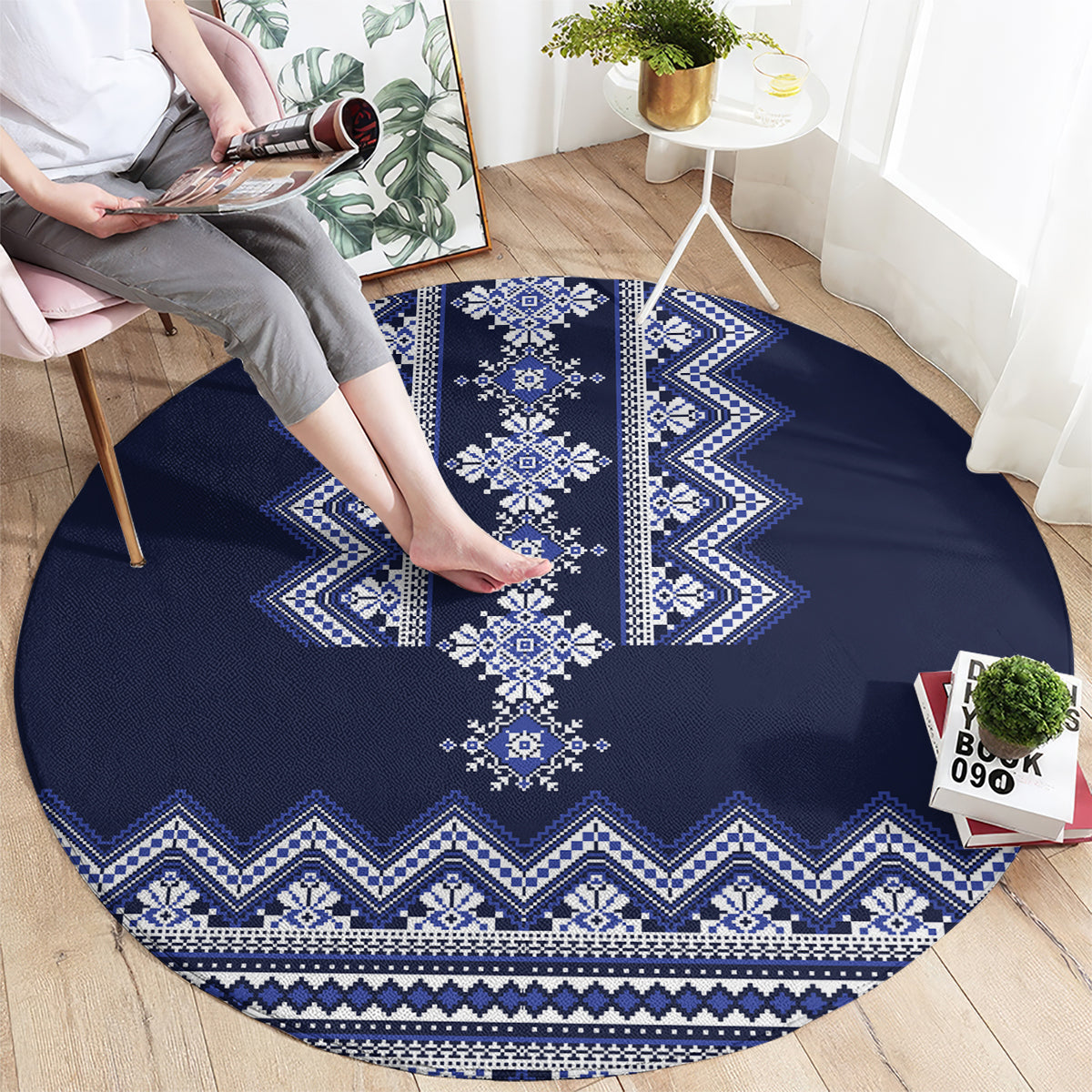 Round navy blue rug with central white diamond medallion and zigzag border