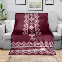 Wine red folk pattern throw blanket draped over sofa with white geometric border