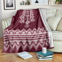 Wine red folk pattern blanket draped across sofa with white geometric stripe