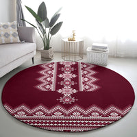 Wine red round rug featuring a white central medallion and zigzag folk border