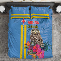 Blue bedding set with tropical owl print, pink flowers, and bold yellow stripe accents.