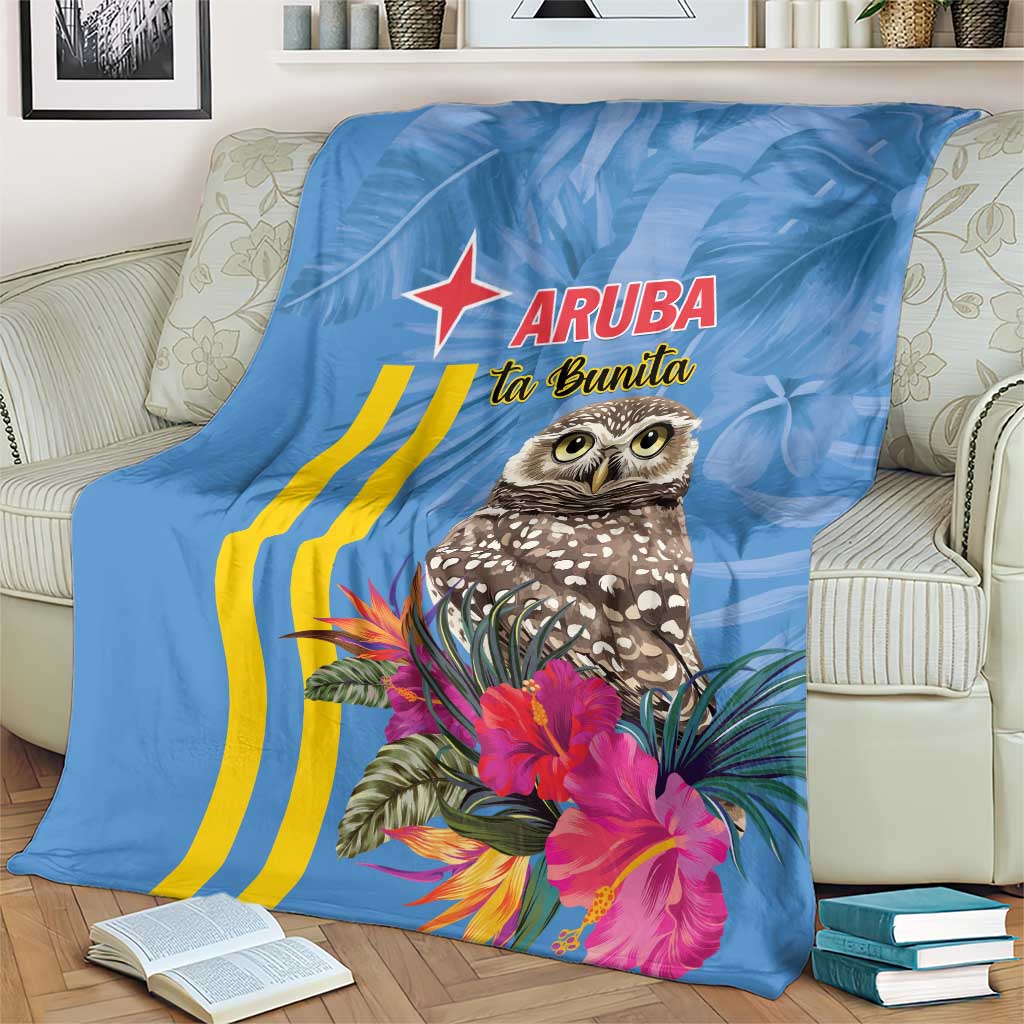 Blue blanket with Aruba logo, owl image, yellow stripes, and pink flowers