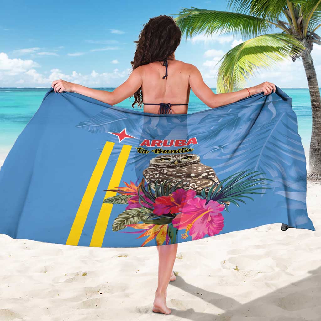 Blue tropical sarong worn with full owl, pink flowers, and Aruba La Bonita logo