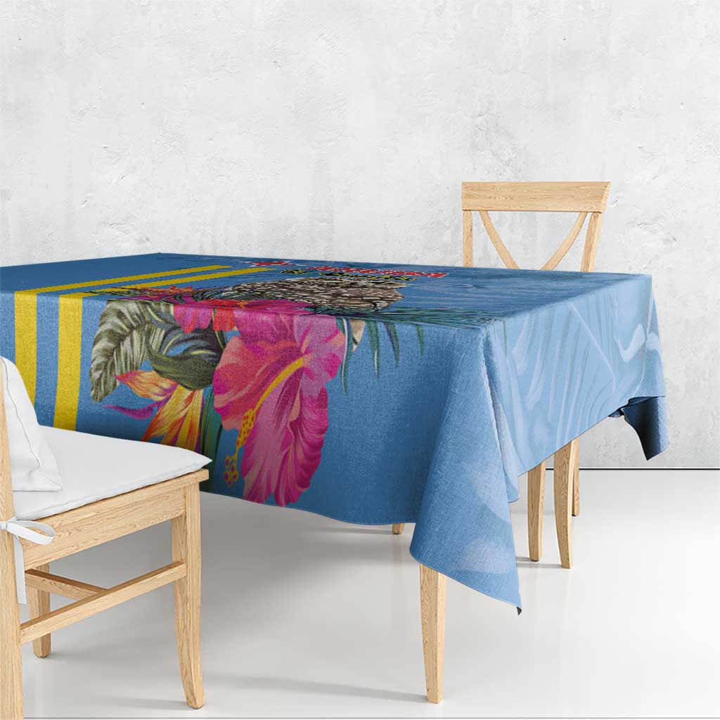 Blue tablecloth with tropical flowers, green palm leaves, and yellow stripe accents