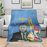 Blue Aruba flag style blanket draped on sofa, featuring portrait, star, and Betico text