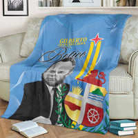 Blue Aruba flag style blanket on bed/sofa, with portrait print and colorful crest details