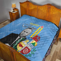 Blue quilt blanket on bed, quilted texture with portrait and Aruba-style flag graphic