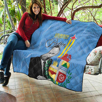Blue quilt blanket draped on sofa, quilted texture with portrait and Aruba-style flag graphic