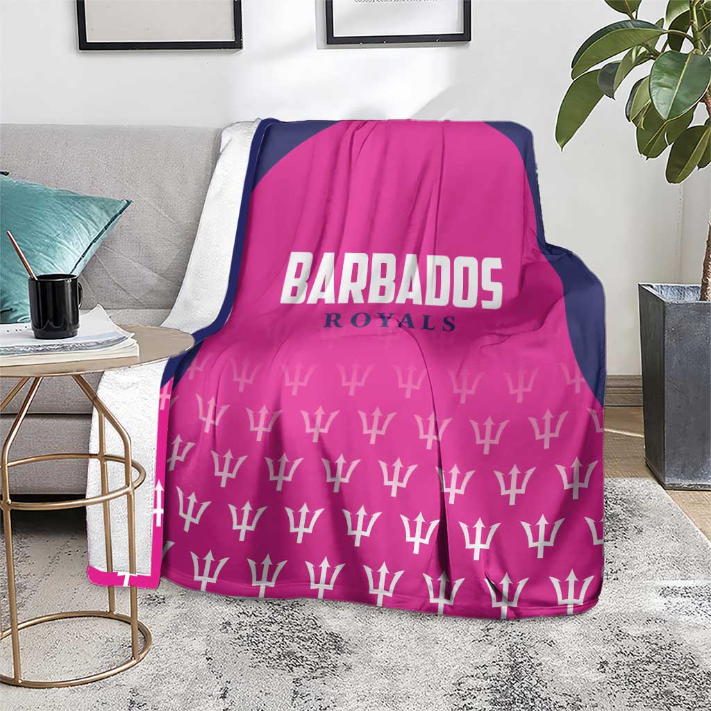 Pink and navy cricket blanket on sofa featuring BARBADOS ROYALS logo and white trophy pattern