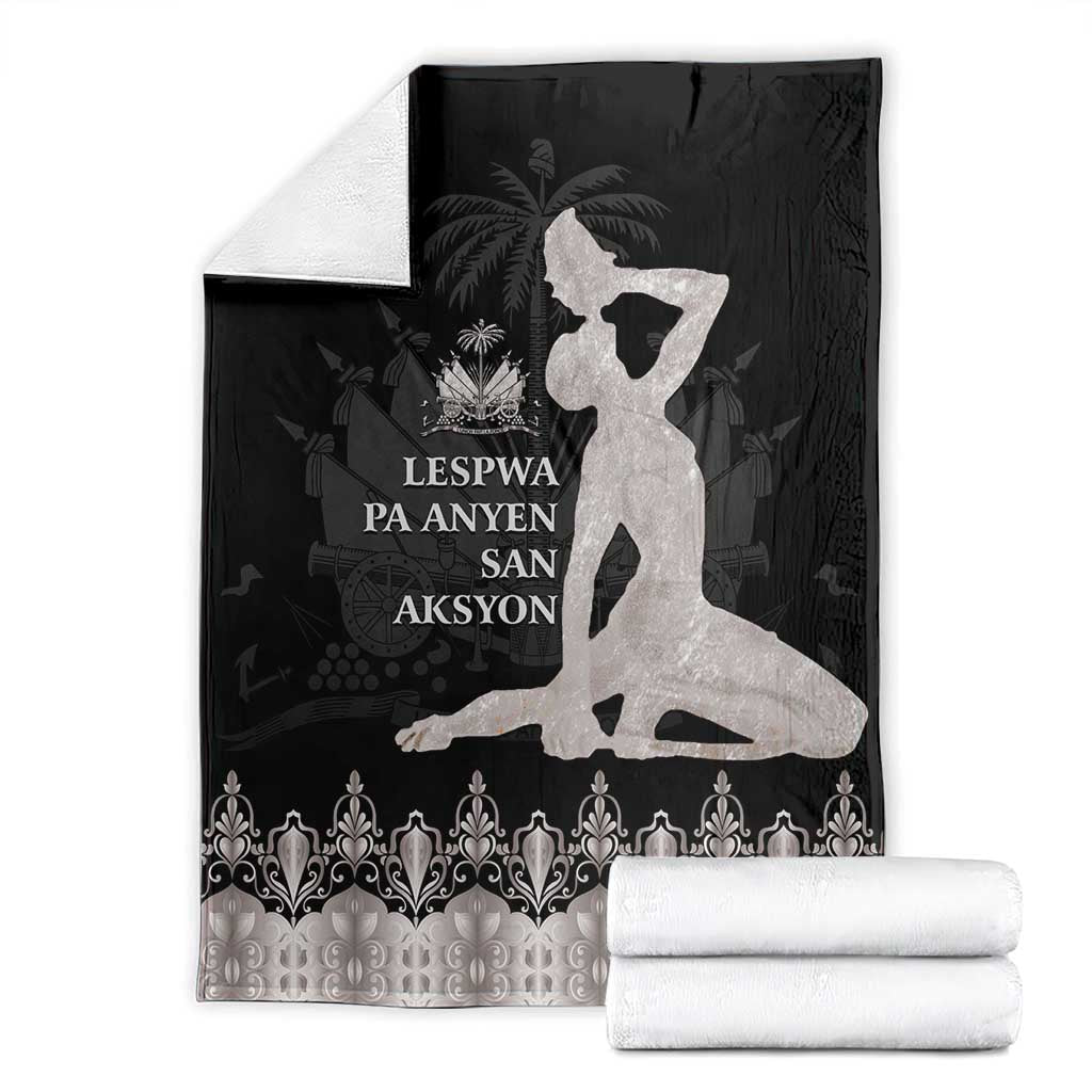 Black and silver blanket with white silhouette design, folded with stack of white towels