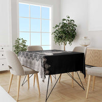 Silver tablecloth with black floral and ornamental pattern, draped over dining table