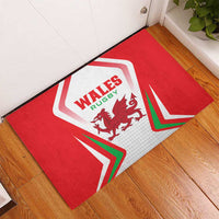 Red Wales Rugby doormat on wooden floor, angled view of shield and tricolor chevrons