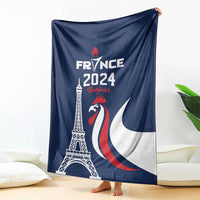 Blue blanket hanging indoors with Eiffel Tower, rooster emblem, and France 2024