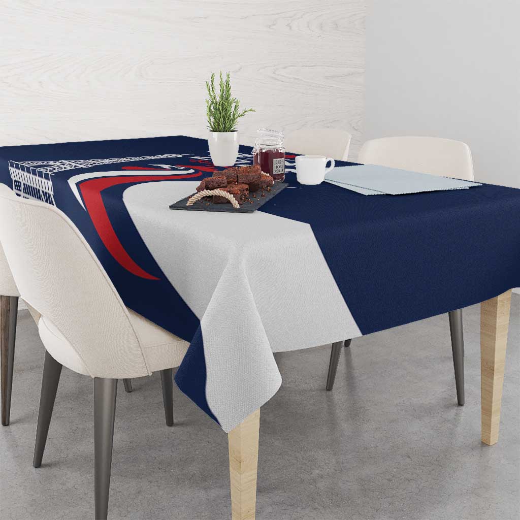 Blue printed tablecloth with Eiffel Tower graphic, draped over dining table.