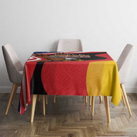 Eagle heritage tablecloth with black red yellow design, draped over chair-backed table