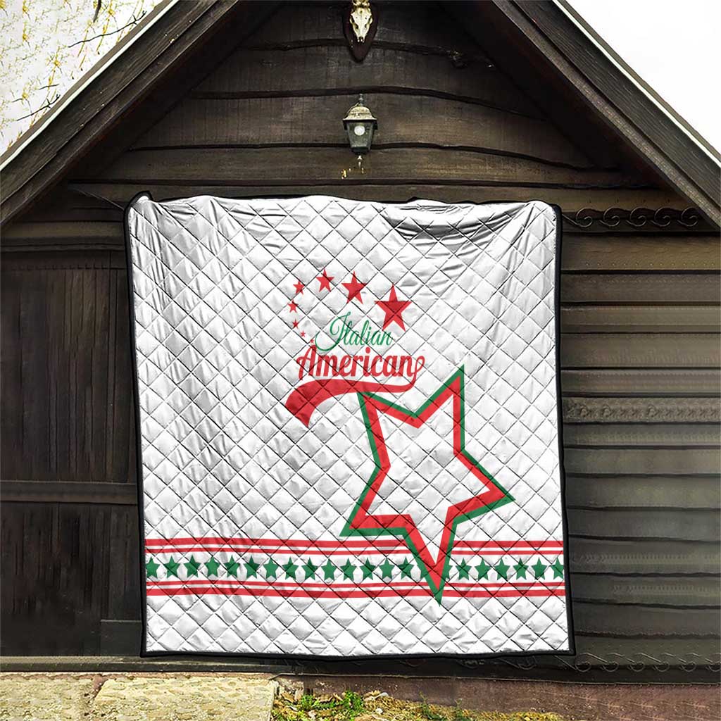 White quilt hanging on outdoor wall, diamond pattern with Italian American red and green stars