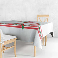 White tablecloth detail showing red and green star border across the fold