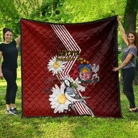 Red quilt shown unfolded with Latvian stripes, daisies, crest badge, and bird print