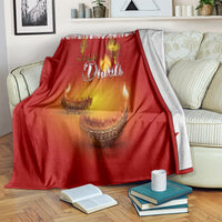 Red Diwali blanket with paisley design and diya glow, draped over couch