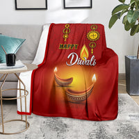 Red paisley Diwali blanket on armchair, 'Happy Diwali' and diya flames