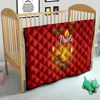 Red Diwali quilt in a baby crib with Happy Diwali script and diya candle artwork