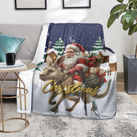 Christmas throw blanket draped on couch with Santa, reindeer, and 'Christmas' script, dark blue
