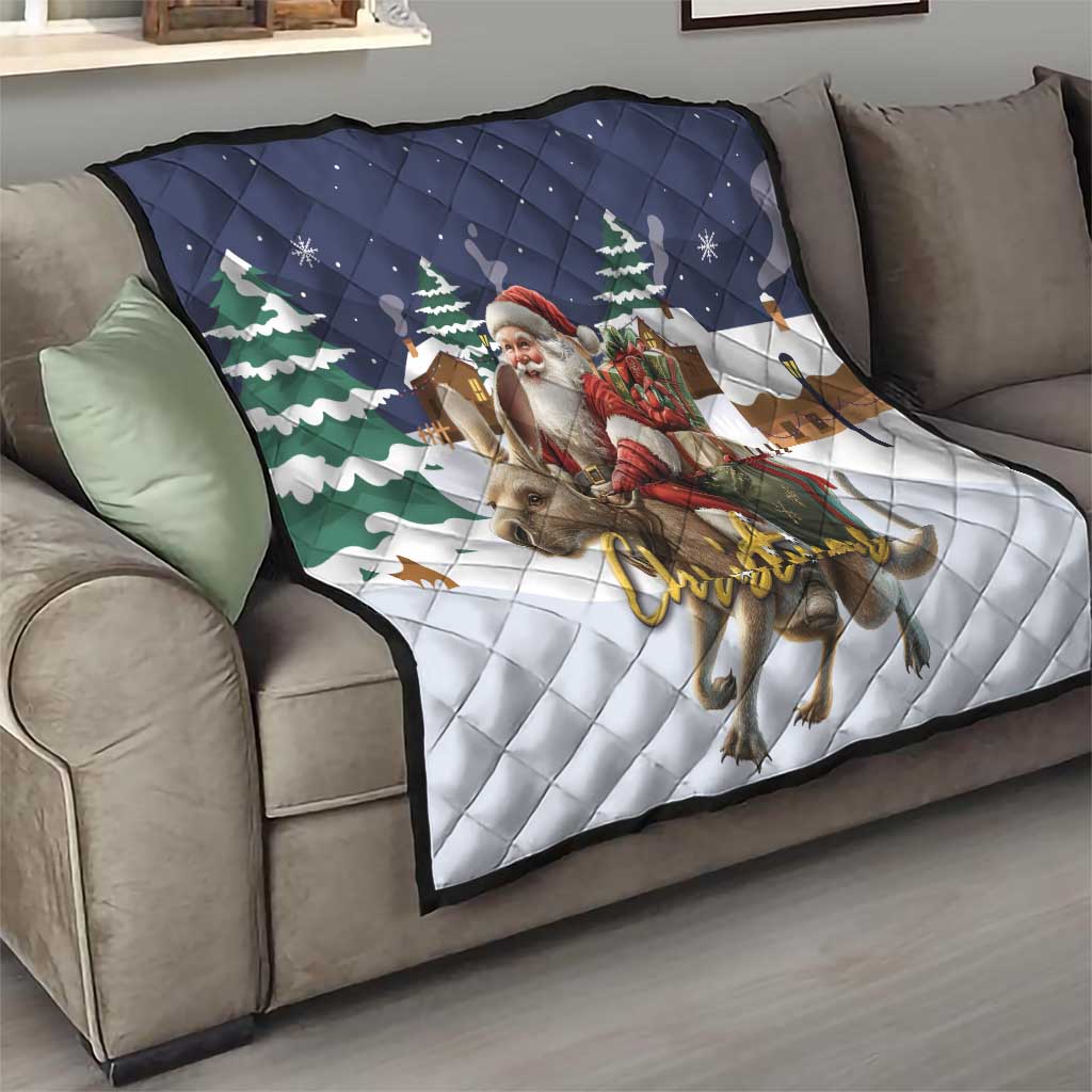 Navy and white Christmas quilt on sofa showing Santa, reindeer, and pine tree graphics
