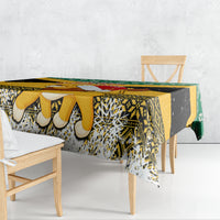 Christmas tablecloth draped on table with yellow, black, green and decorative border
