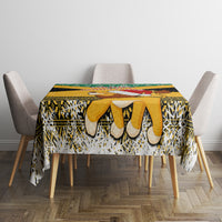 Yellow, black, white and green Christmas tablecloth with festive pattern and border