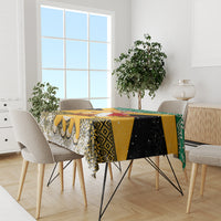 Yellow, black, white and green Christmas tablecloth on dining table with draped sides