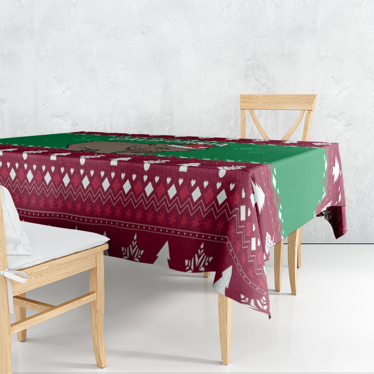Christmas tablecloth draped over table with maroon geometric pattern, green side panel, tree motifs