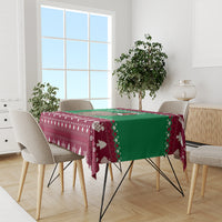 Christmas tablecloth on dining table with maroon-and-green border and white tree designs