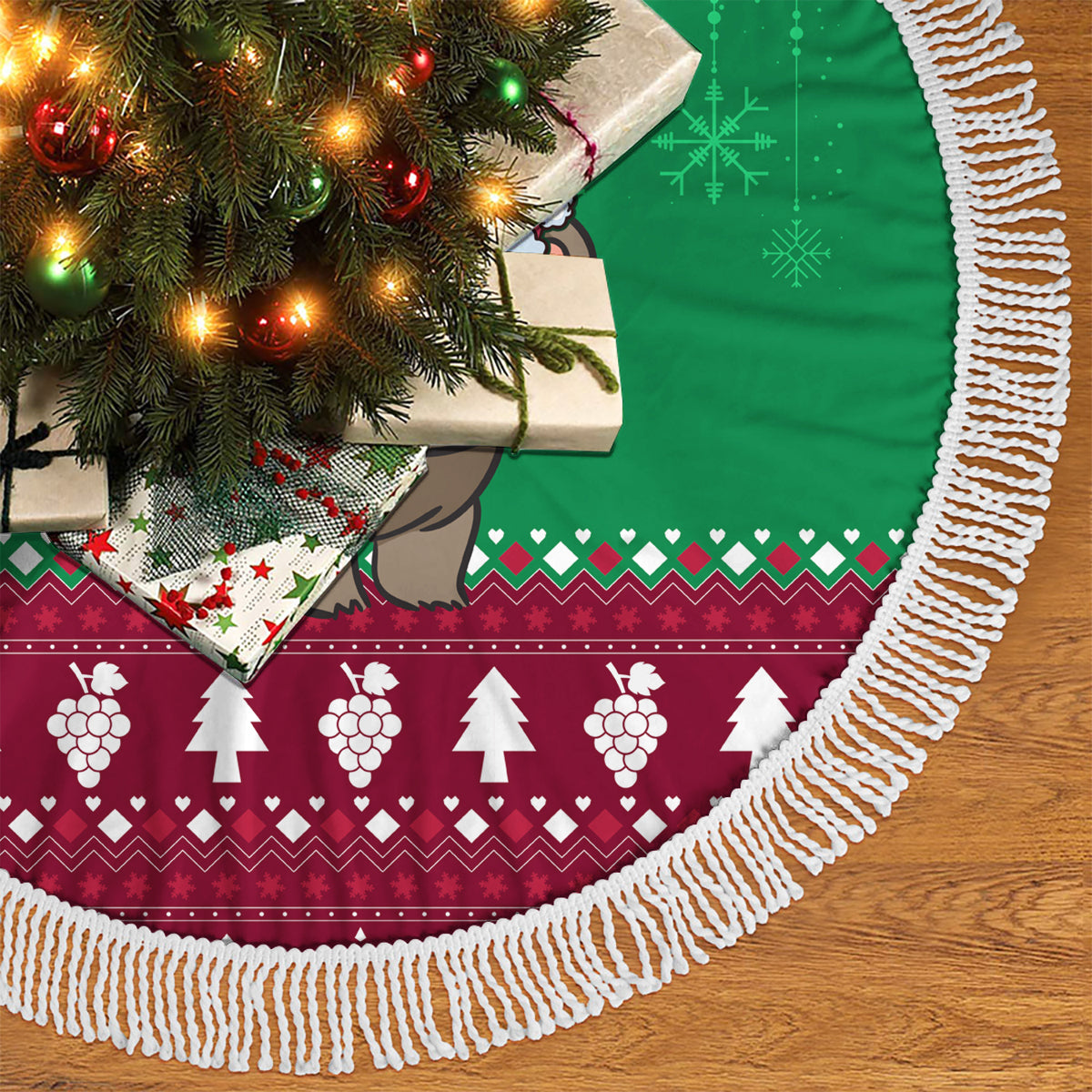 Fringed Christmas tree skirt with green top and burgundy hem, bear graphic partially visible.