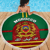 Round Morocco beach blanket, green with tassel fringe and coat-of-arms emblem