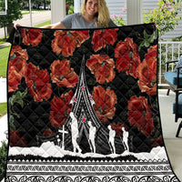 Black quilt with red poppies and Polynesian-style pattern border, featuring a white monument design