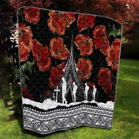 Black quilt featuring red poppies, white monument-and-figure design, and ornate Polynesian border