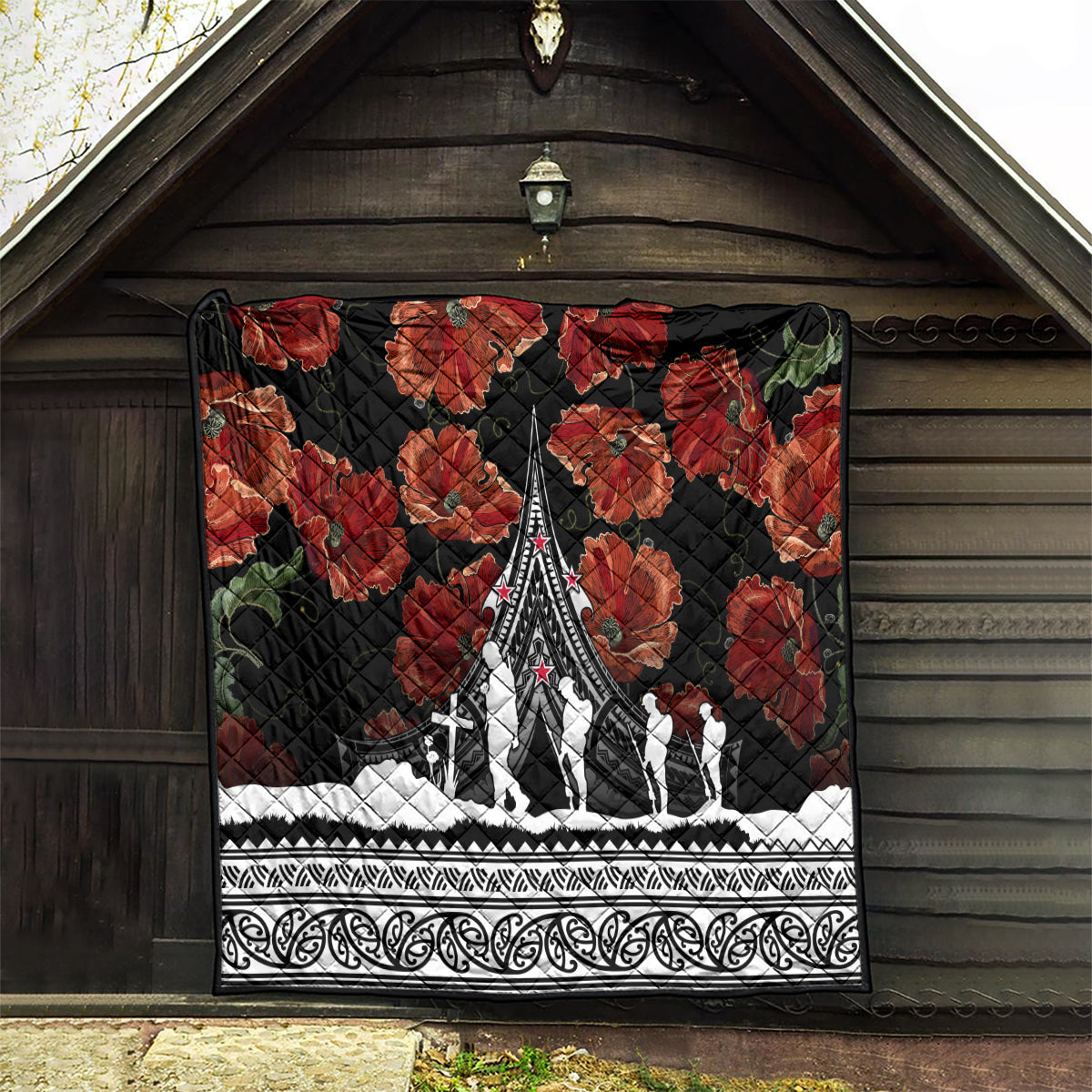Black quilt with red poppies and white Polynesian border, central white monument and figures