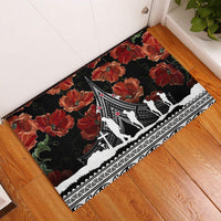 Black rubber doormat with red poppies and white Polynesian pattern, with silhouettes
