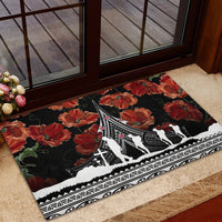 Black rubber doormat with red poppies and white war memorial silhouettes in frame