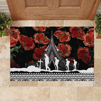 Black rubber doormat with red poppies and central memorial tower, white tribal border