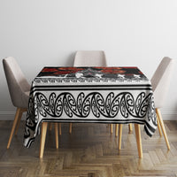 Black tablecloth with white swirl border and red floral band, covering dining table