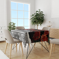 Black tablecloth with red poppies and ornate white stripe, laid on dining table