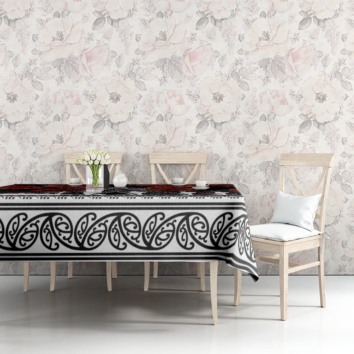 Black tablecloth with red poppies and white scroll border on table in bright room