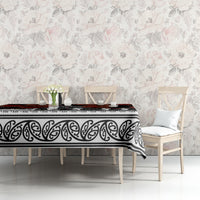 Black tablecloth with red poppies and white scroll border on table in bright room