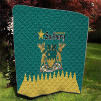 Green quilt laid on grass with Greater Sudbury crest and yellow zigzag bottom