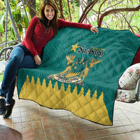 Green quilt held outdoors showing Greater Sudbury crest and yellow zigzag pattern
