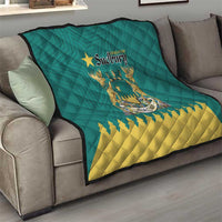 Green quilt draped on a couch with Greater Sudbury crest and yellow zigzag design
