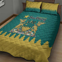 Teal and yellow quilt bed set with emblem and star pattern, styled on bed with pillows