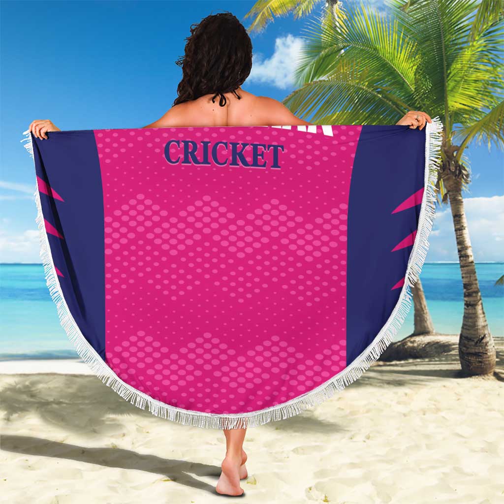 Round pink beach blanket held open, navy side panels, white fringe edge, CRICKET text