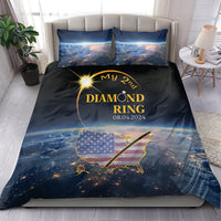 Total eclipse bedding set on bed: black/blue duvet cover with gold ring design and pillows